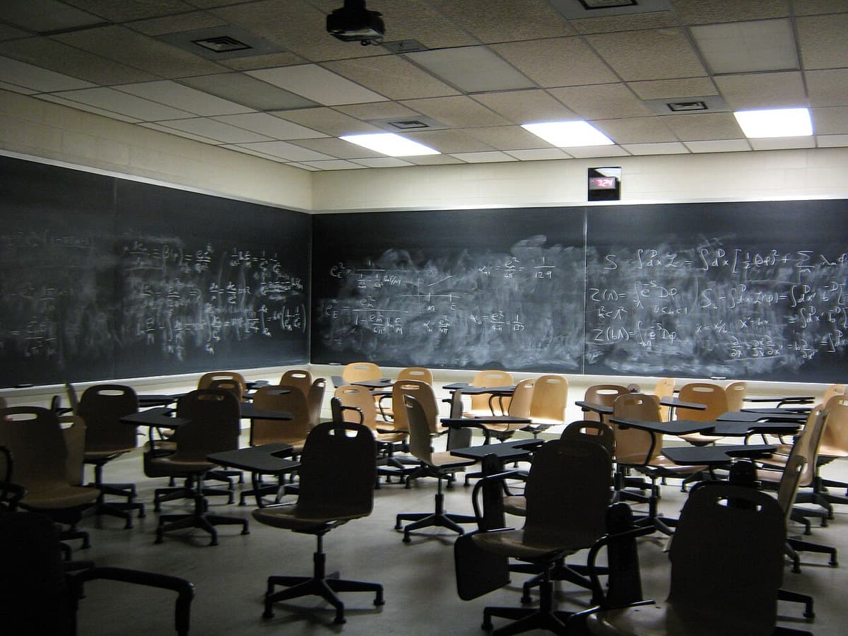 An empty classroom with desks and blackboards